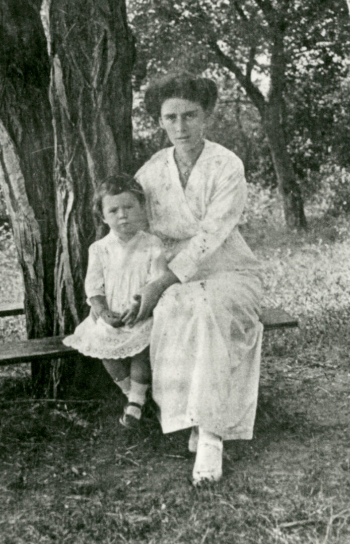 DX726/8 Gwladys Cartwright with daughter Ella Cecil sitting on bench around tree in garden, c1916